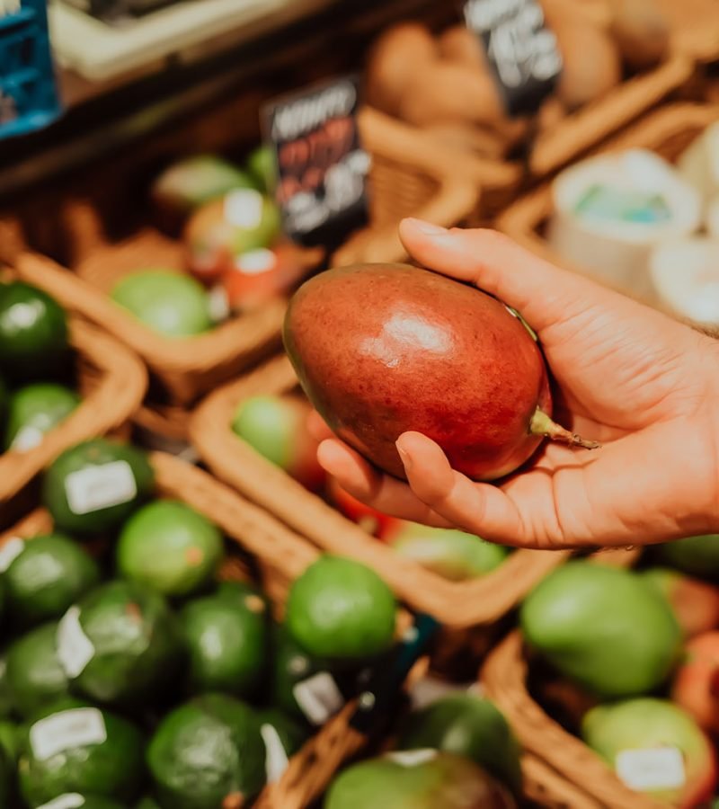 man-picks-mango-tropical-fruit-in-supermarket-or-2025-03-09-18-36-29-utc